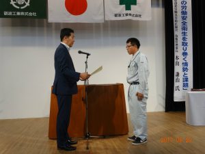 安全衛生優良表彰を受ける　土木部　菊池　学さん（山王川用水路工事における安全管理活動報告もしてもらいました）