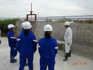 水路の中に降りて、既設の水路が傷んでいることの説明を受けています。